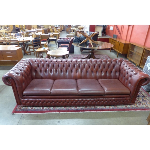 107 - An oxblood red leather Chesterfield settee