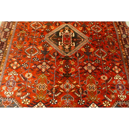 138 - An Iranian Qashqai woollen pile, wool foundation red ground rug, 162 x 260cms