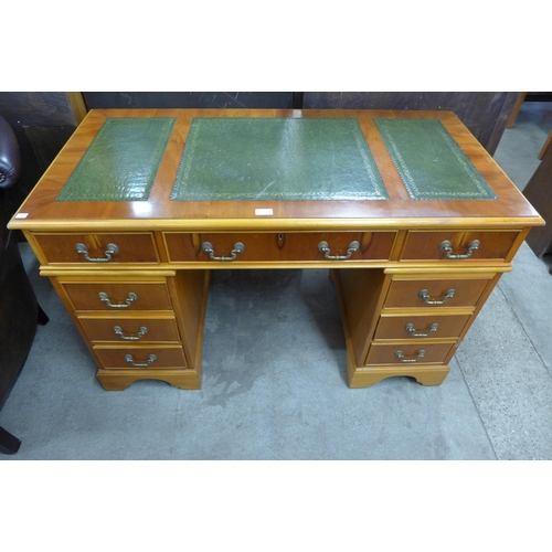 154 - A yew wood and green leather topped pedestal desk