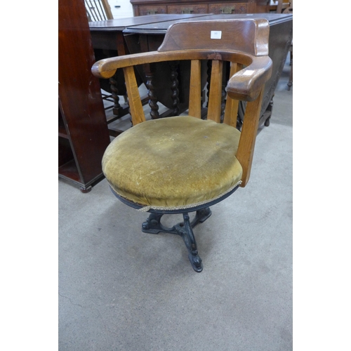 183 - A Victorian oak and cast iron based revolving desk chair