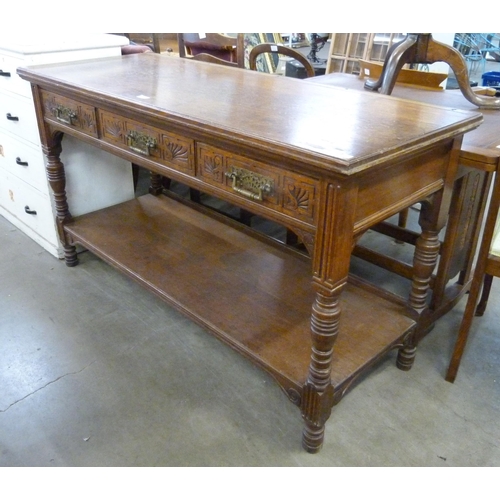 227 - A Victorian Aesthetic Movement carved oak three drawer serving table