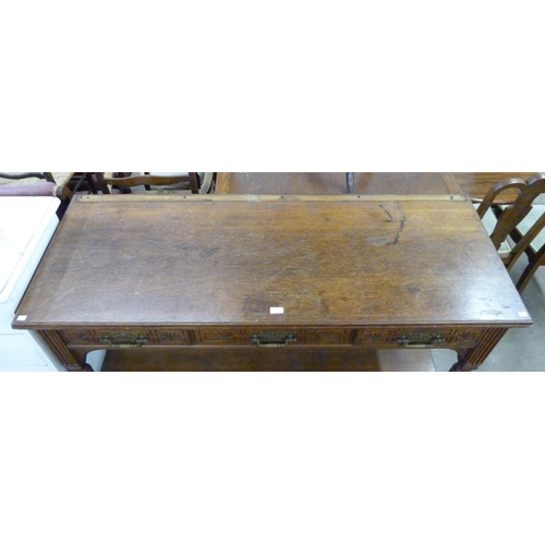 227 - A Victorian Aesthetic Movement carved oak three drawer serving table