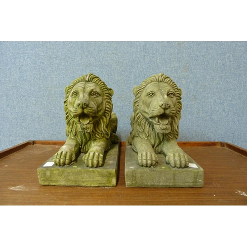 295 - A pair of concrete garden figures of recumbent lions