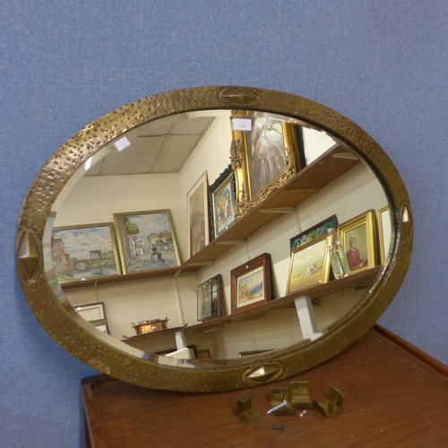 351 - An Arts and Crafts oval brass framed mirror