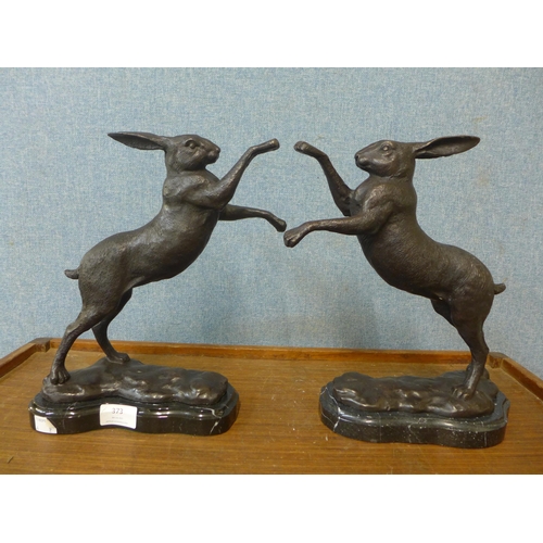 373 - A pair of French style bronze figures of boxing hares, on black marble socles