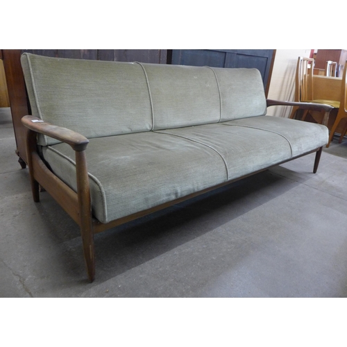 63 - A Guy Rodgers teak and green fabric upholstered settee/daybed. This lot is offered as a work of art,... 