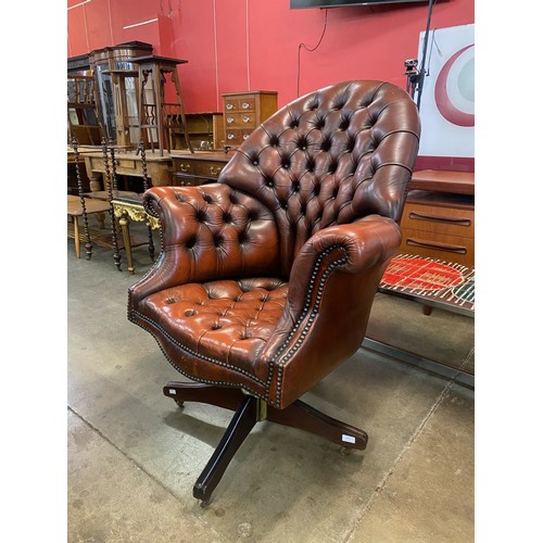 131 - A chestnut brown leather Chesterfield revolving desk chair