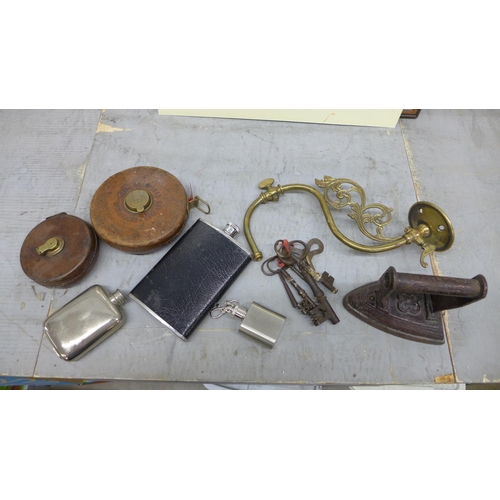 Assorted items; hip flasks, keys, tape measures, a wall light fitting