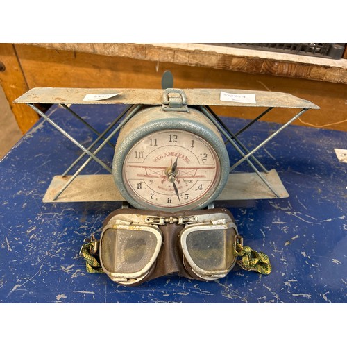 2118 - A novelty aeroplane clock and a pair of aviator goggles