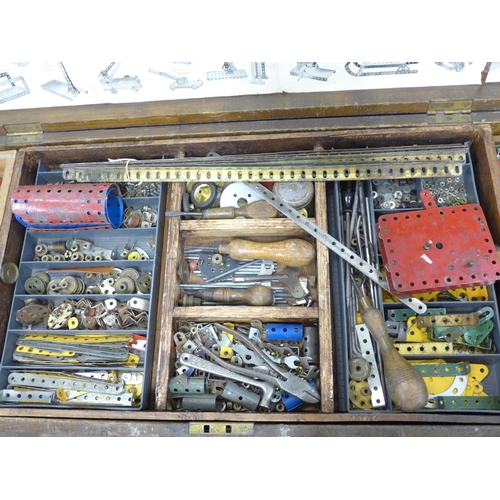 810 - A large collection of vintage Meccano in an oak case including tools, accessories, etc., double laye... 