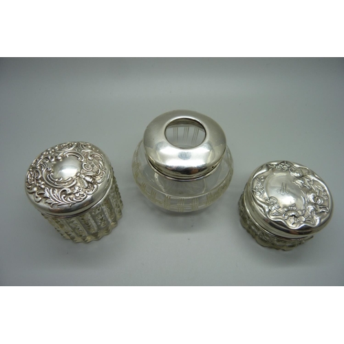 877 - Three silver topped glass jars, 29g