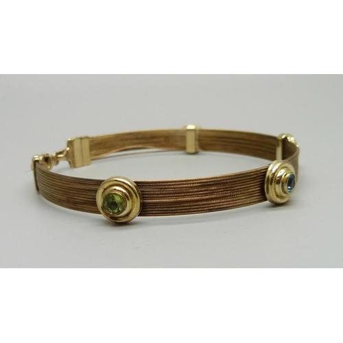 957 - A 9ct gold, topaz and peridot bracelet, 8.9g