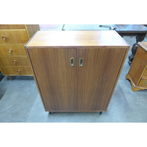 21 - A teak two door shoe cupboard