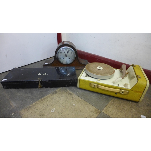 278 - An H.M.V. table top gramophone, a portable record player, an oak mantel clock and a tin