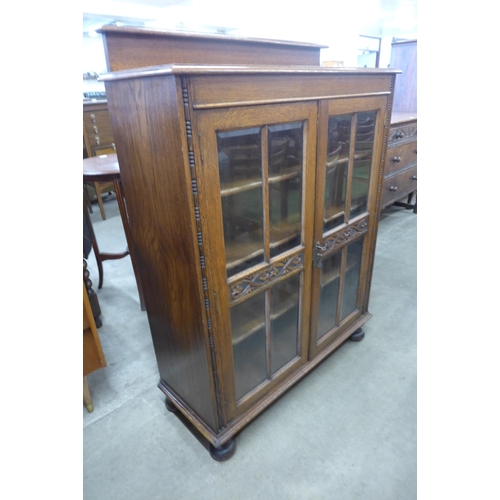 66 - An early 20th Century carved oak two door bookcase