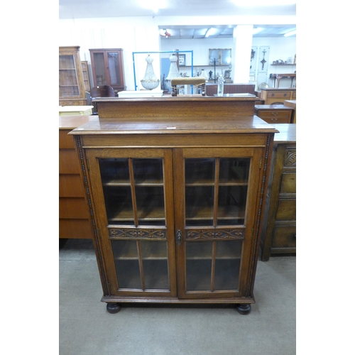 66 - An early 20th Century carved oak two door bookcase