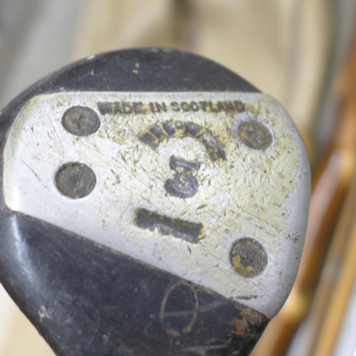 808 - Vintage golf clubs and walking sticks in a vintage golf bag