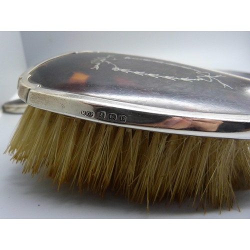 874 - A silver brush set, a silver and tortoiseshell hand mirror and a similar brush