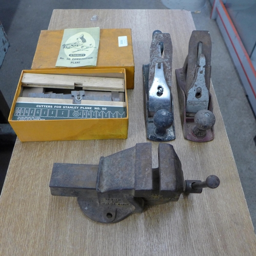 2035 - A Stanley No.50 plough plane, box with blades & 2 wood planes and bench vice