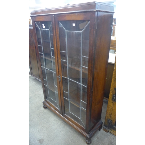 106 - An early 20th Century oak and leaded glass two door bookcase