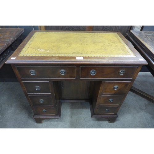 141 - A George I style mahogany and tan leather topped kneehole desk