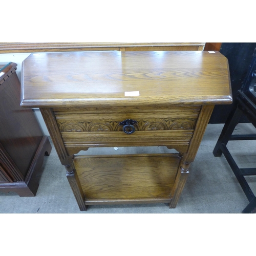 165 - A carved oak single drawer credence table