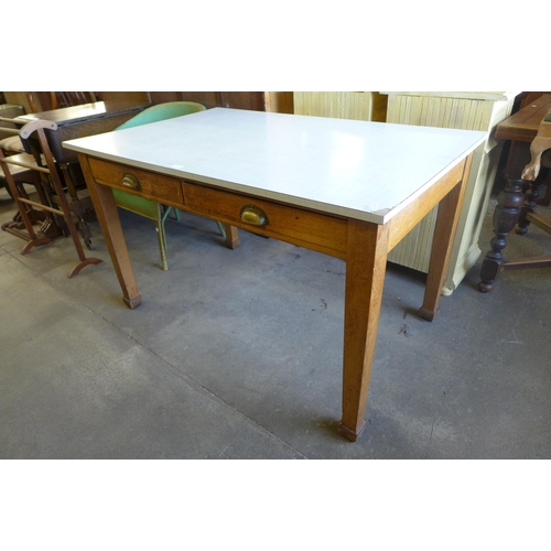 197 - An early 20th Century oak two drawer kitchen table, with later associated laminate top