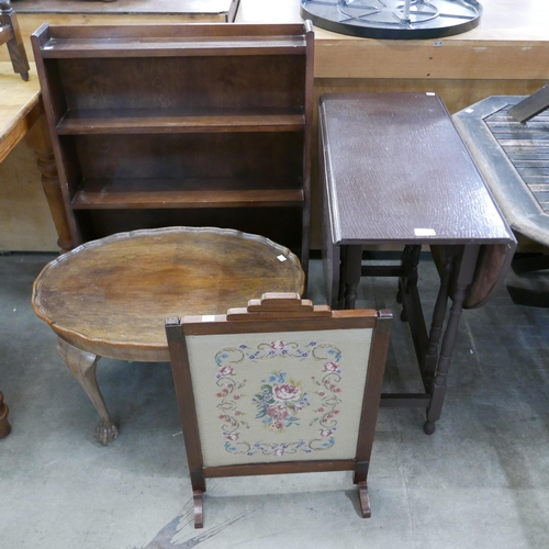 225 - An oak open bookcase, a gateleg table, a walnut coffee table and an embroidered fire screen