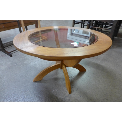 91 - A teak and glass topped circular coffee table