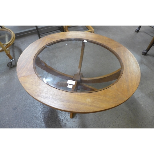 91 - A teak and glass topped circular coffee table