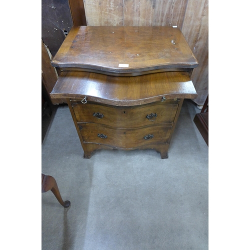 105 - A George III style walnut serpentine bachelors chest of drawers