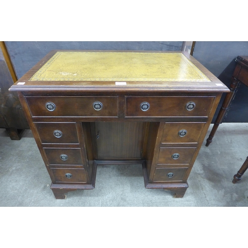 110 - A George I style mahogany and tan leather topped kneehole desk