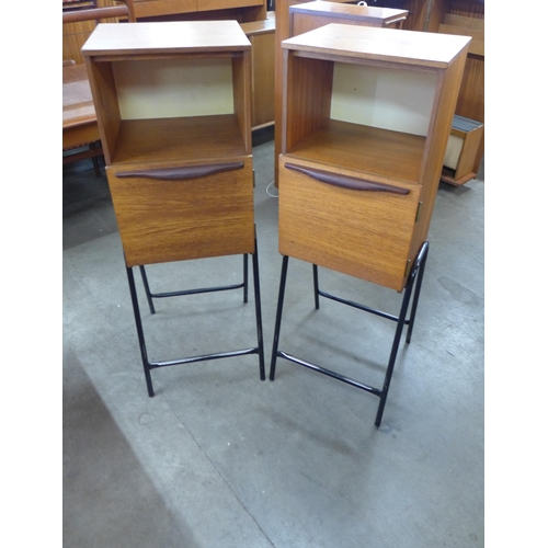 17 - A pair of teak cabinets on black metal stands