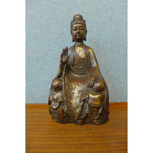 275 - An oriental bronze figure of a seated deity