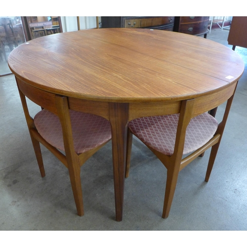 51 - A Nathan teak circular extending dining table and four chairs