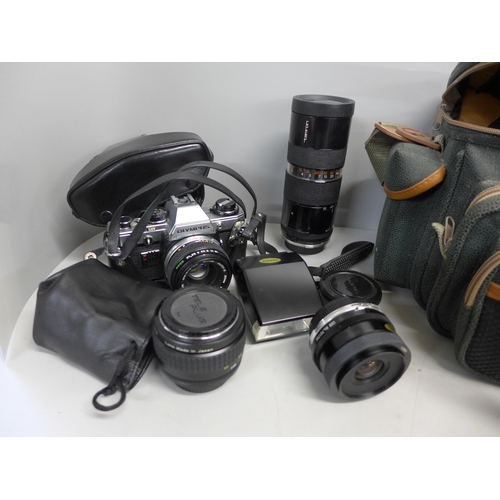 771 - An Olympus OM10 camera, three additional lenses, accessories and a bag