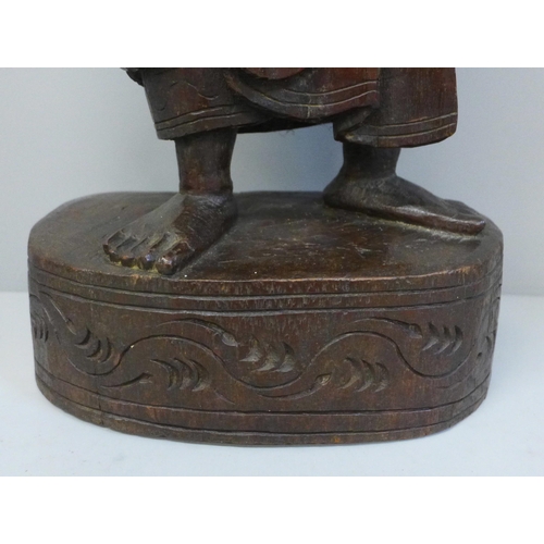 790 - A mid 19th Century oriental wood carving of a figure, probably Burmese, height 57cms