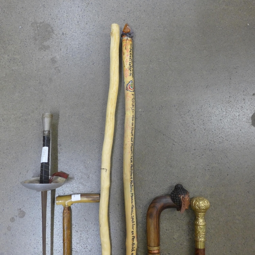 827 - Two wooden staffs, three walking sticks and a fencing sword