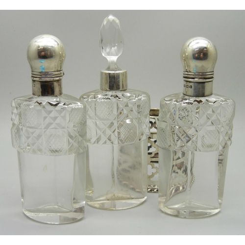 879 - A silver mounted trio of scent bottles in stand, Birmingham 1906