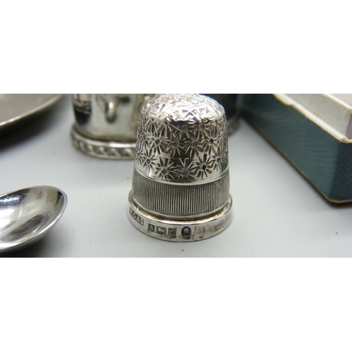 935 - Three silver napkin rings, 62g, a pair of silver salt spoons, a silver thimble, three glass salts an... 