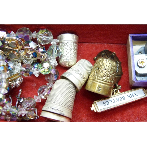 956 - A musical jewellery box containing silver thimbles, a Beatles pendant and costume jewellery