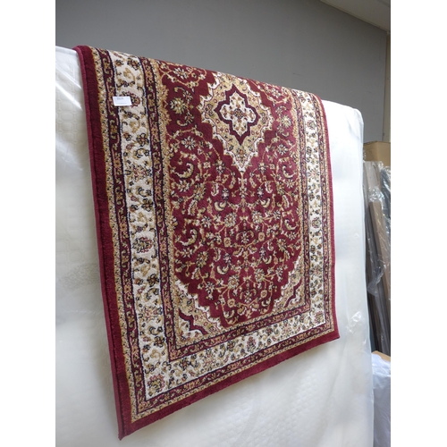 1624 - A patterned red ground hall runner rug