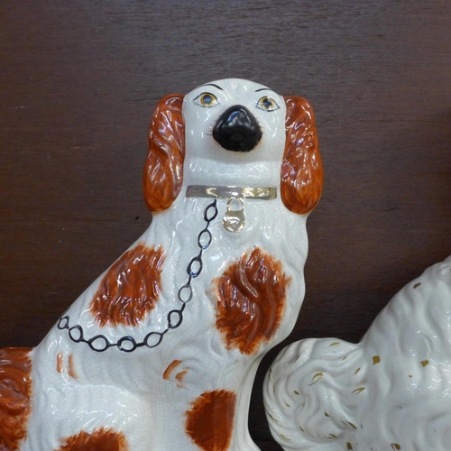 602 - A pair of Staffordshire spaniels, 28.5cm and one other