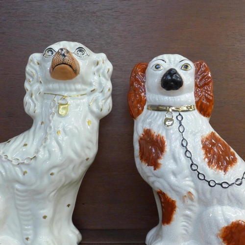 602 - A pair of Staffordshire spaniels, 28.5cm and one other