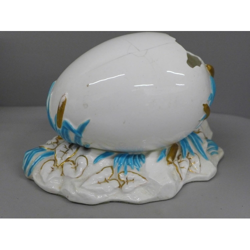 650 - A German porcelain figural spill holder and egg ornament, both a/f