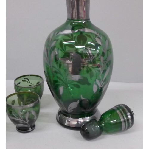 695 - A liqueur set; silver overlay green glass decanter and six glasses