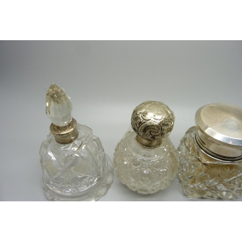 849 - Four silver topped glass scent bottles/dressing table pots, including a scent bottle in the shape of... 