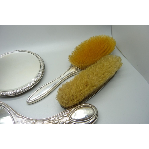 893 - A silver backed Art Nouveau hand mirror, Birmingham 1906, one other mirror, a/f, and two silver back... 