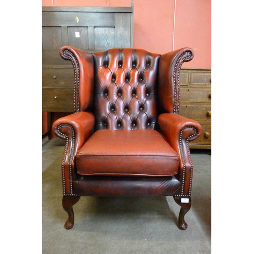 112 - A red leather Chesterfield wingback armchair