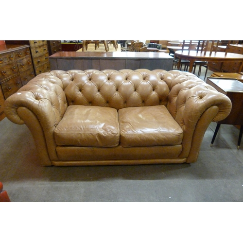 113 - A tan leather Chesterfield settee